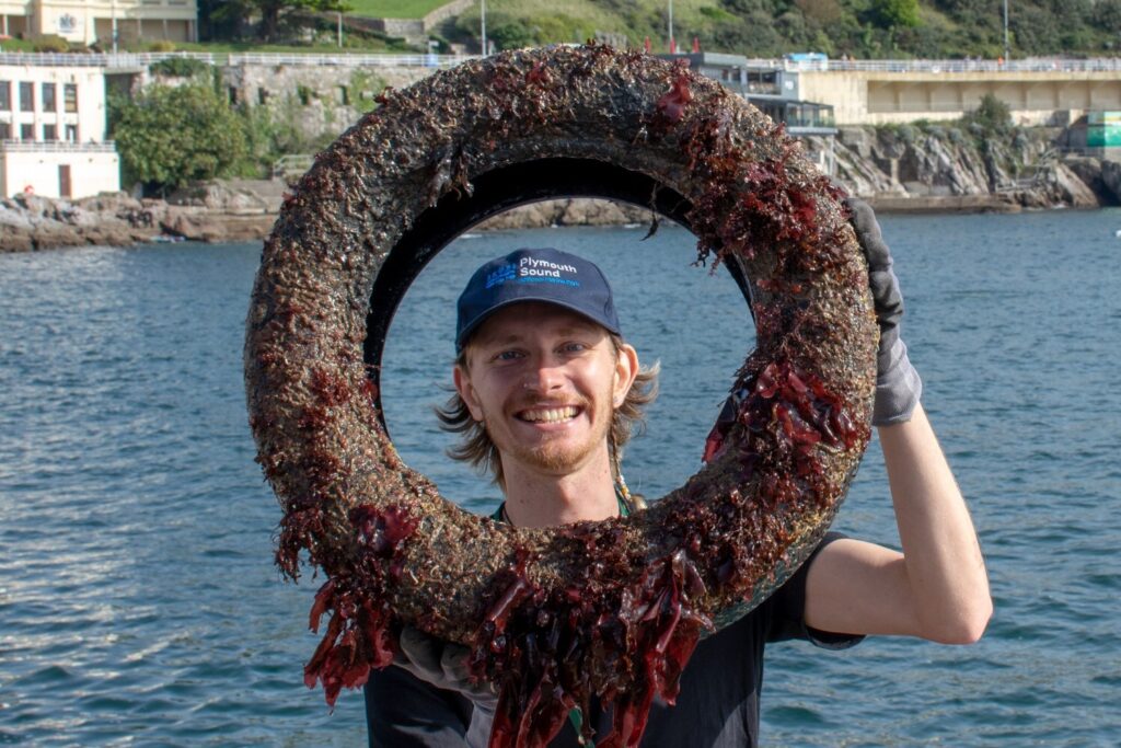 Plymouth Sound National Marine Park Ranger Nick Helm holding a tyre reclaimed from the sea