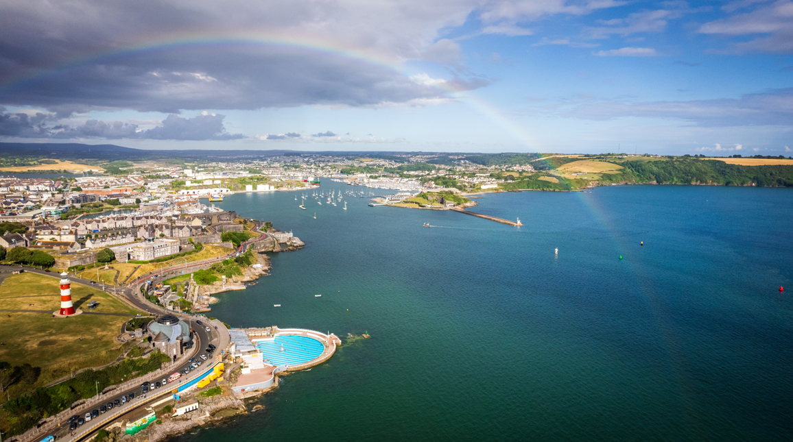 A drone shot of Plymouth Sound National Marine Park with a rainbow.