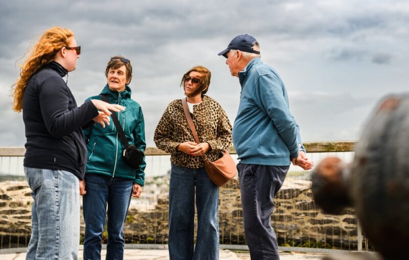 Millie talking to three people at the top of Mount Batten Tower, overlooking Plymouth Sound