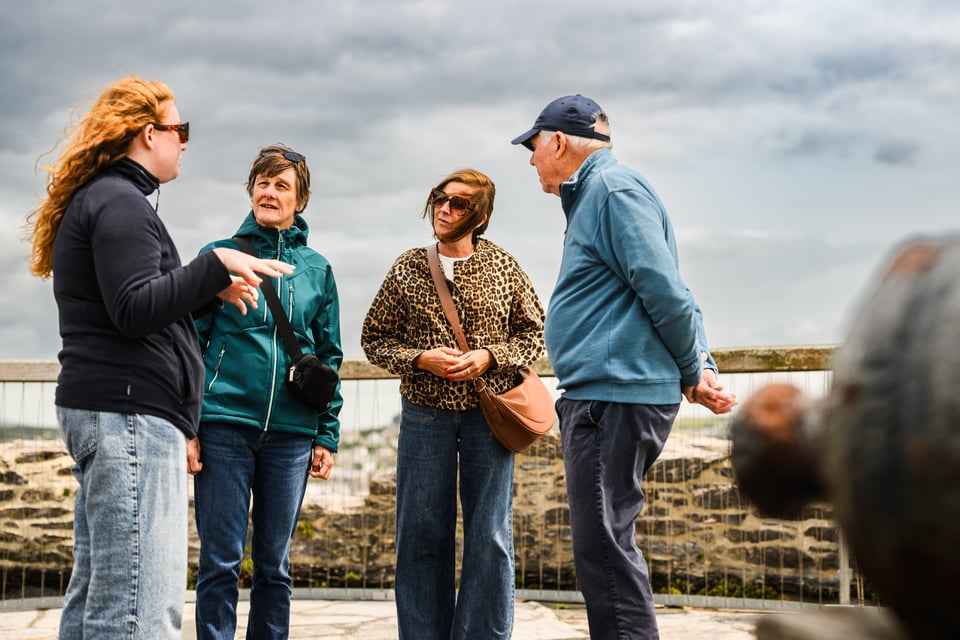 Millie talking to three people at the top of Mount Batten Tower, overlooking Plymouth Sound