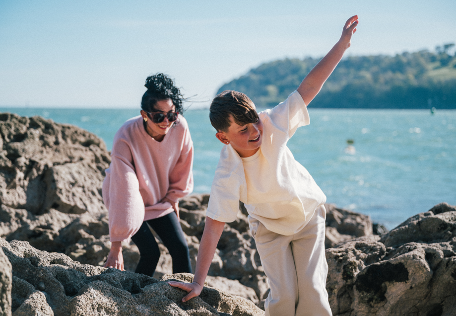 Mother and son climbing over the rocky shore at Plymouth Sound National Marine Park