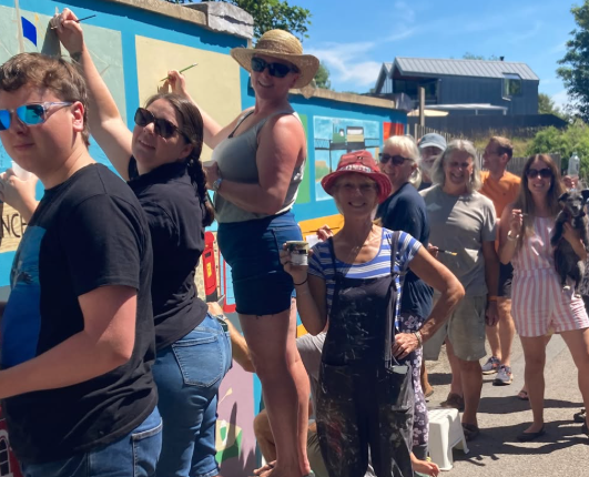 Blue Sparks - Turnchapel History Group - A group of people painting a mural in Turnchapel that signifies the area's maritime history