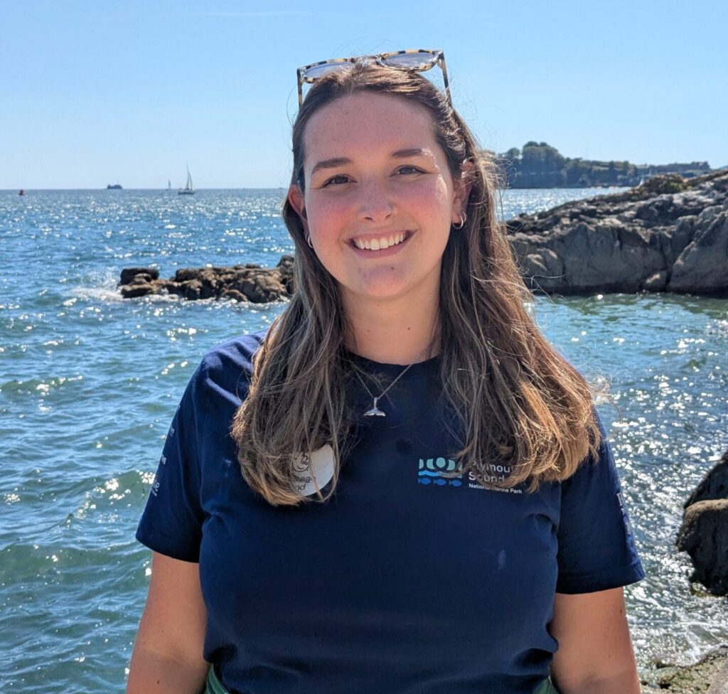 A portrait of the National Marine Park project support officer, Jess Jarvis with the background of Plymouth Sound.